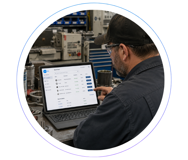 Spare Parts Final Two manufacturing professionals reviewing data on a laptop, representing real-time SAP integration and system uptime.